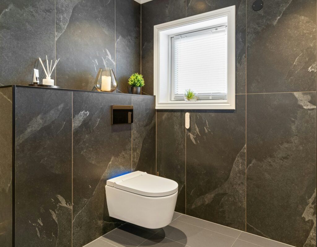 Alicatado de baño con azulejos de gran formato de color oscuro en baño moderno