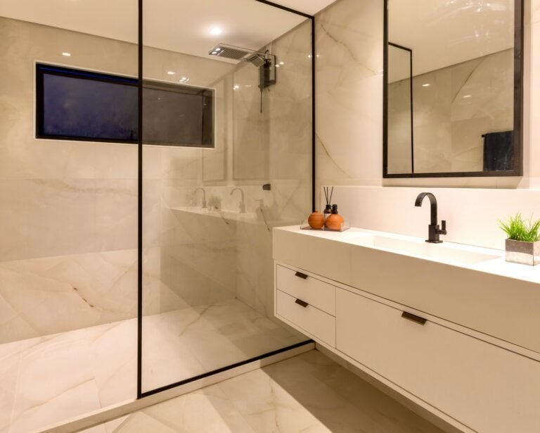 Ducha de obra a ras de suelo con arena y mampara de cristal — resultado de cambiar la bañera por ducha en un baño reformado