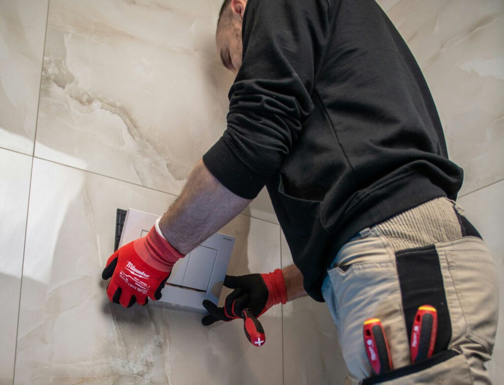 Fontanero trabajando reparando defecto en la descarga de un baño
